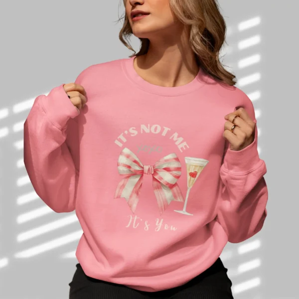 It’s Not Me It’s You sweatshirt with bow and champagne glass design on Gildan 18000 crewneck - Safety Pink