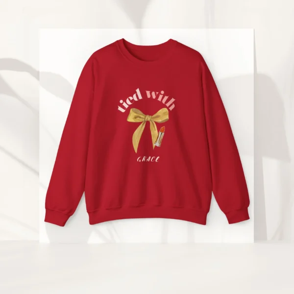 Tied with grace sweatshirt with bow and lipstick design on Gildan 18000 - Red Flatlay