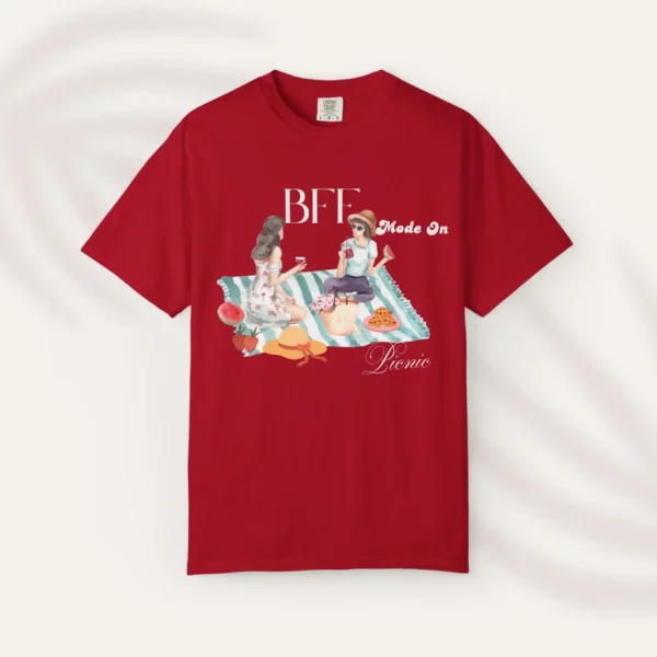 BFF Mode On Tee with watercolor illustration of two girls enjoying a picnic with fruit, waffles, a basket & drinks on striped blanket on Comfort Colors 1717 - Red Flatlay