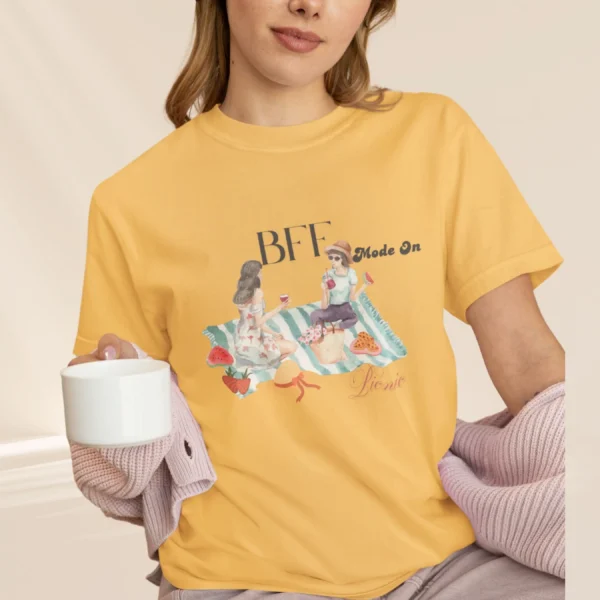 BFF Mode On Tee with watercolor illustration of two girls enjoying a picnic with fruit, waffles, a basket & drinks on striped blanket on Comfort Colors 1717 - Citrus