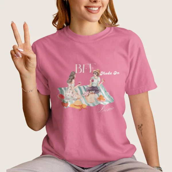 BFF Mode On Tee with watercolor illustration of two girls enjoying a picnic with fruit, waffles, a basket & drinks on striped blanket on Comfort Colors 1717 - Crunchberry