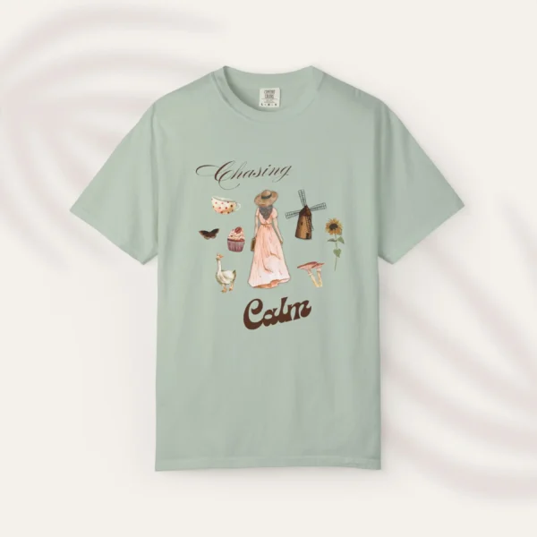 Chasing Calm Tee with cottage girl, geese, florals, and windmill on Comfort Colors 1717 - Bay Flatlay