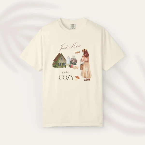 Just Here for the Cozy Tee with cottage and girl illustration on Comfort Colors 1717 - Ivory Flatlay