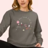 Sweatshirt with “You Look Like Poetry Today” quote and soft illustrated aesthetic elements like perfume, lipstick, ribbons, and hearts - Pepper